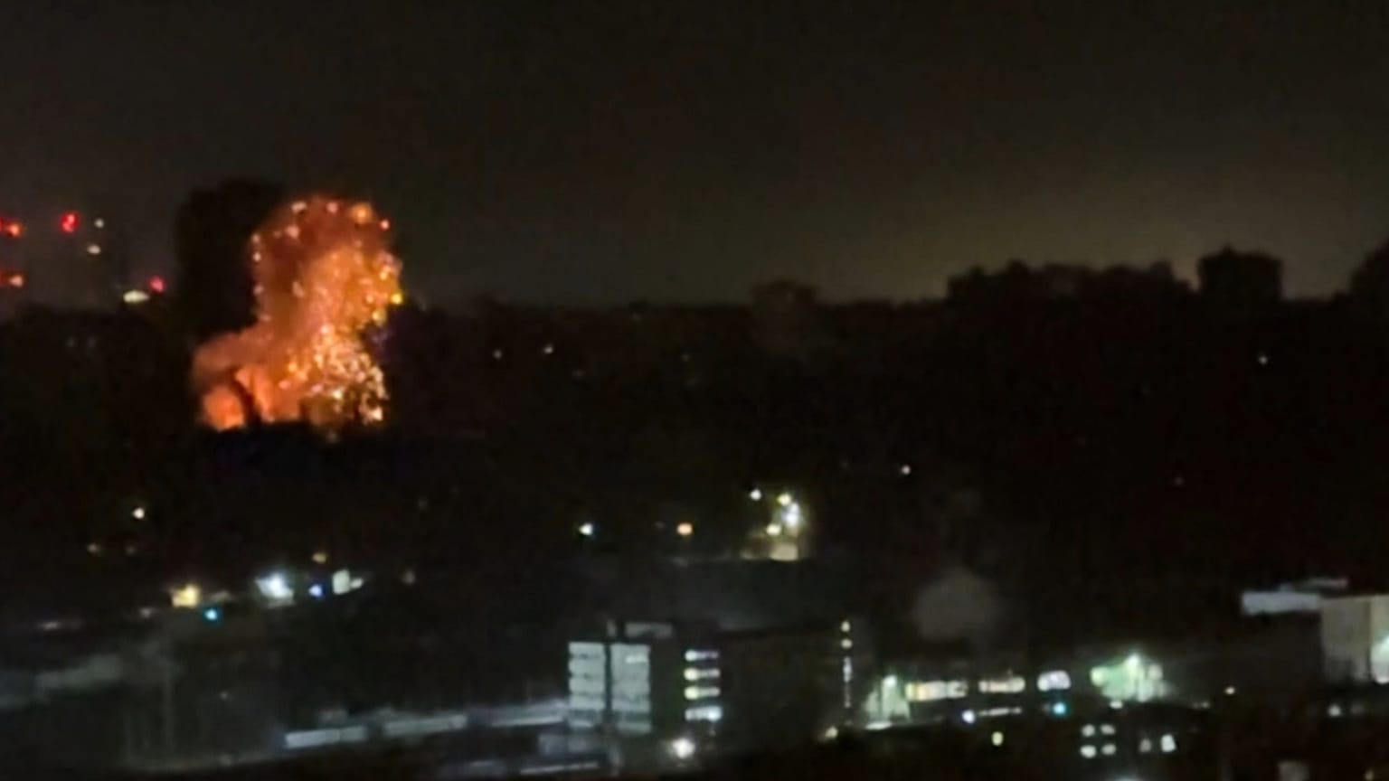 In this image taken from video, an explosion is seen in the distance as a Russian attack targets Ukraine's Kyiv region on Friday, Nov. 14, 2025.