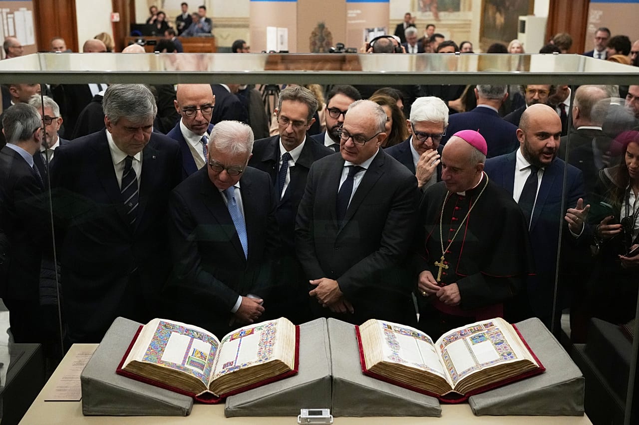 From right, Monsignor Rino Fisichella, Rome's Mayor Roberto Gualtieri and Italian government undersecretary Alfredo Mantovano look at the 15th century Borso D'Este Bible