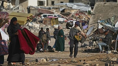 Un Palestinien porte des sacs de bois de chauffage après les avoir ramassés dans les ordures à Khan Younis, dans le sud de la bande de Gaza, le samedi 15 novembre 2025. 