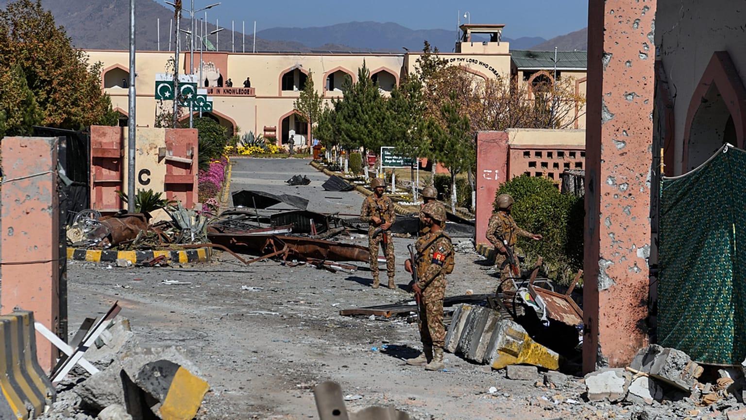 جنود الجيش على الحراسة بجانب منطقة متضررة عند البوابة الرئيسية لكلية الكتّاب العسكرية التي هاجمها مسلحون يوم الإثنين، في مدينة وانا، بإقليم جنوب وزيرستان شمال غرب باكستان