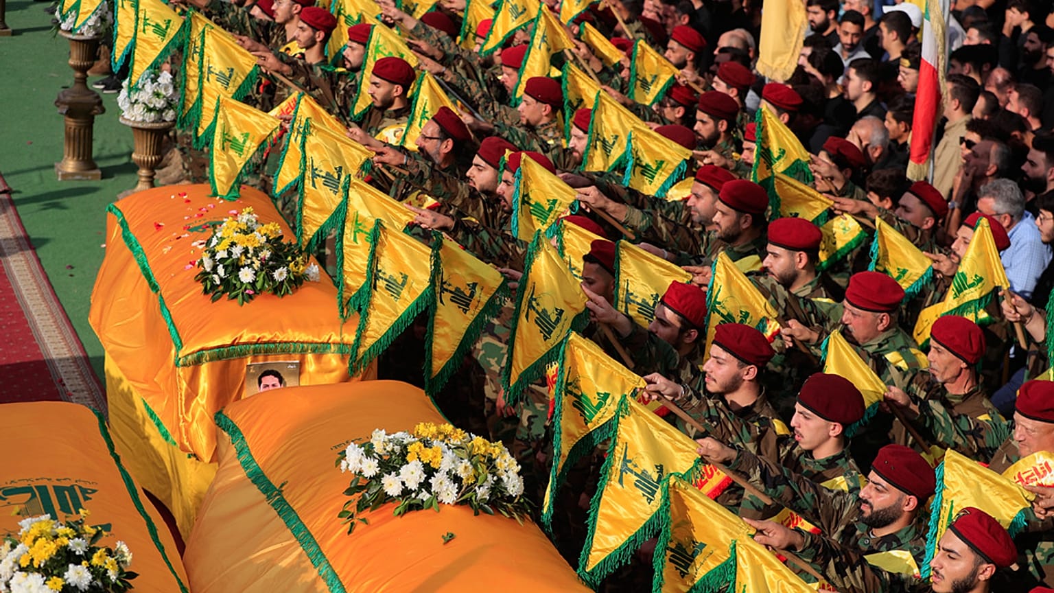 يرفع عناصر حزب الله راياتهم إلى جانب خمسة نعوش في بلدة النبطية جنوبي لبنان، يوم الأحد، 2 تشرين الثاني/نوفمبر 2025.