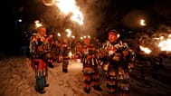 Los kukeri búlgaros encienden sus antorchas mientras realizan el ritual Surva, que celebra el Año Nuevo.
