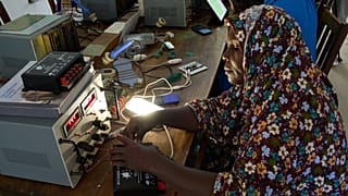 تقوم فنية من برنامج "Solar Mama" بتوصيل منظم شحن شمسي في حرم "Barefoot College International" في كينياسيني، أونغوجا، زنجبار.