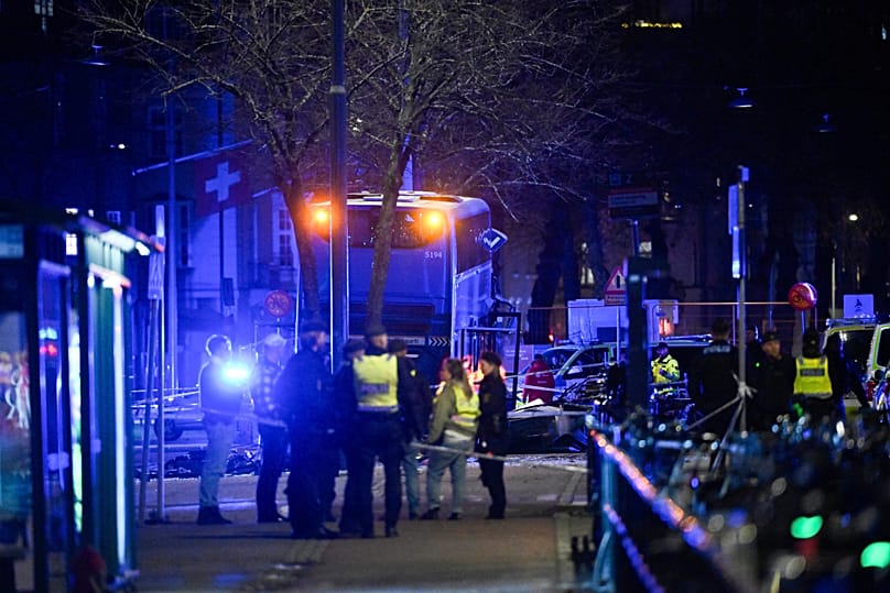 Police stand at the scene where a double-decker bus crashed into a bus shelter in Stockholm, 14 November, 2025