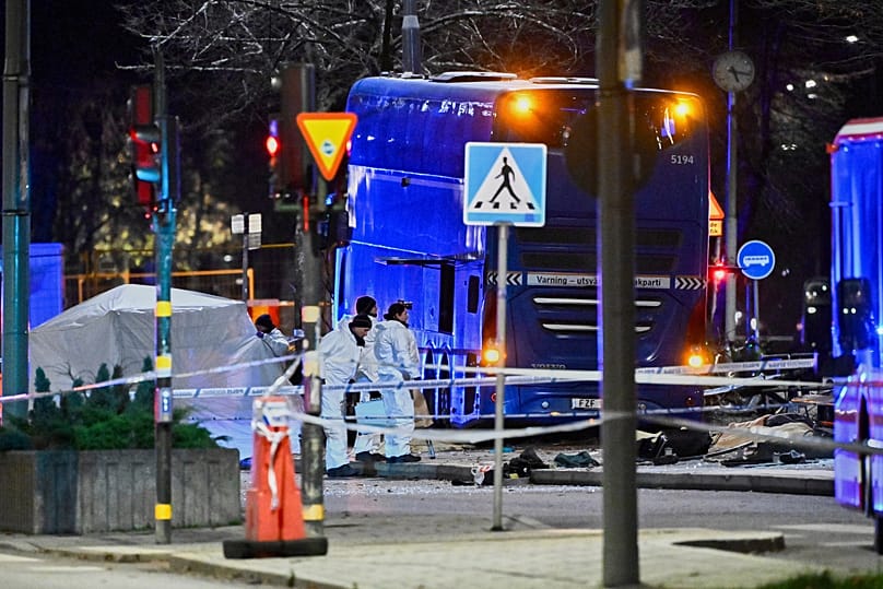 Police stand at the scene where a double-decker bus crashed into a bus shelter in Stockholm, 14 November, 2025