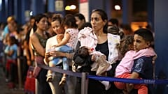 En una foto de archivo datada de 2019, varios migrantes venezolanos esperan para cruzar los controles migrantorios desde Tumbes, Perú, hasta la frontera con Ecuador
