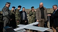 El ministro de Defensa de Grecia, Nikolaos Dendias, segundo por la derecha, toca un dron durante un ejercicio con fuego real cerca de la ciudad nororiental de Alexandroupolis