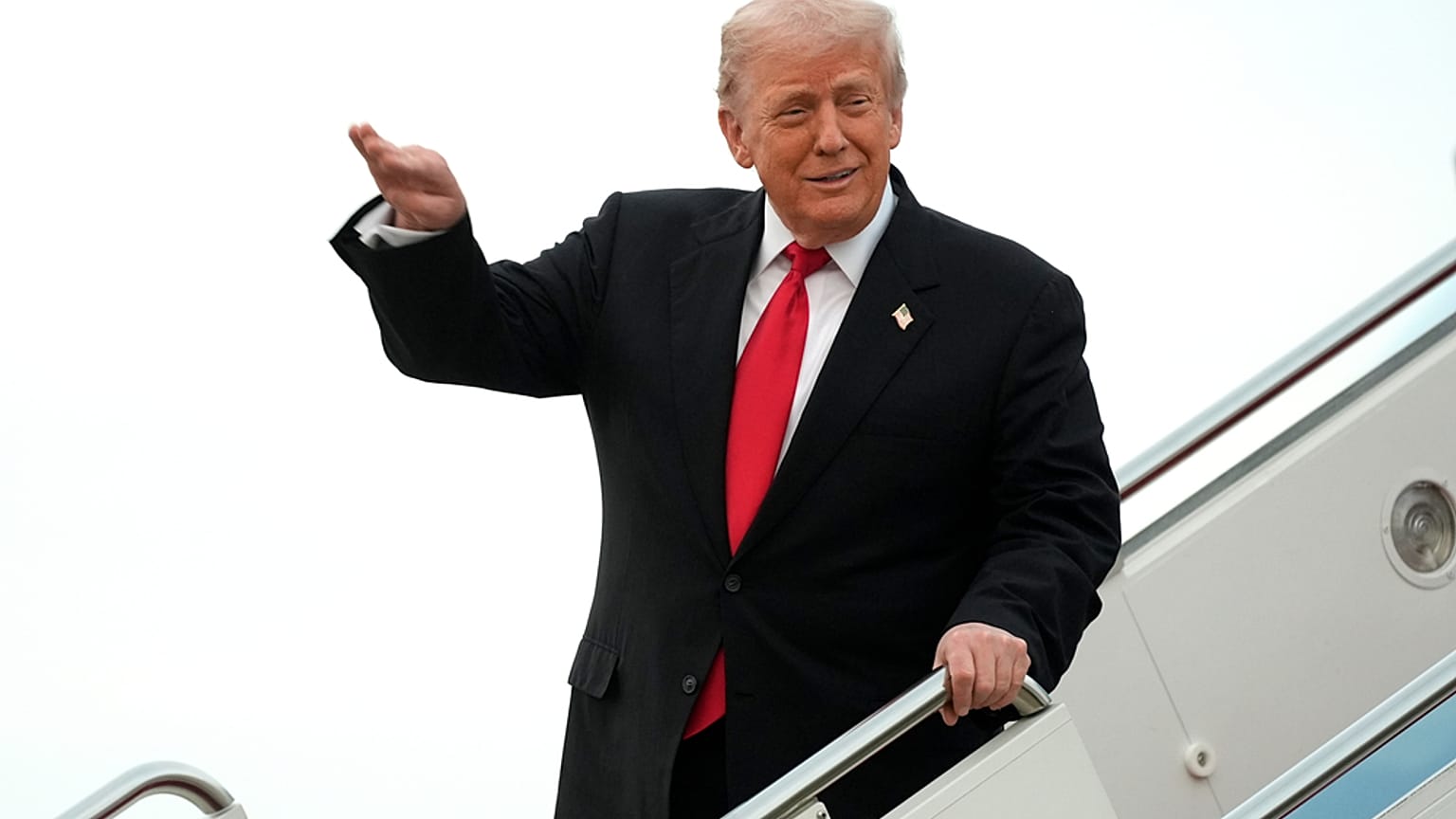 الرئيس دونالد ترامب يلوّح أثناء حديثه عن تحليقه فوق ملعب نورث ويست على متن طائرة الرئاسة "إير فورس وان" عند وصوله إلى قاعدة أندروز المشتركة في ماريلاند