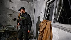 يفحص ضابط من قوات الأمن الداخلي السورية منزلاً في دمشق، سوريا، يوم الجمعة 14 نوفمبر 2025