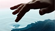 يد تُحاول لمس المياه