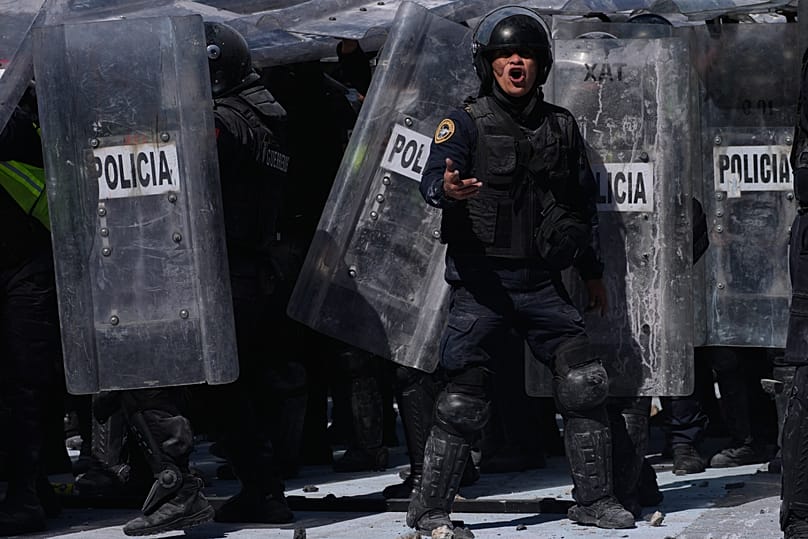 ضابط يصرخ في وجه متظاهرين يهاجمون الشرطة خلال مسيرة شبابية مناهضة للحكومة في مكسيكو سيتي، السبت 15 نوفمبر 2025.