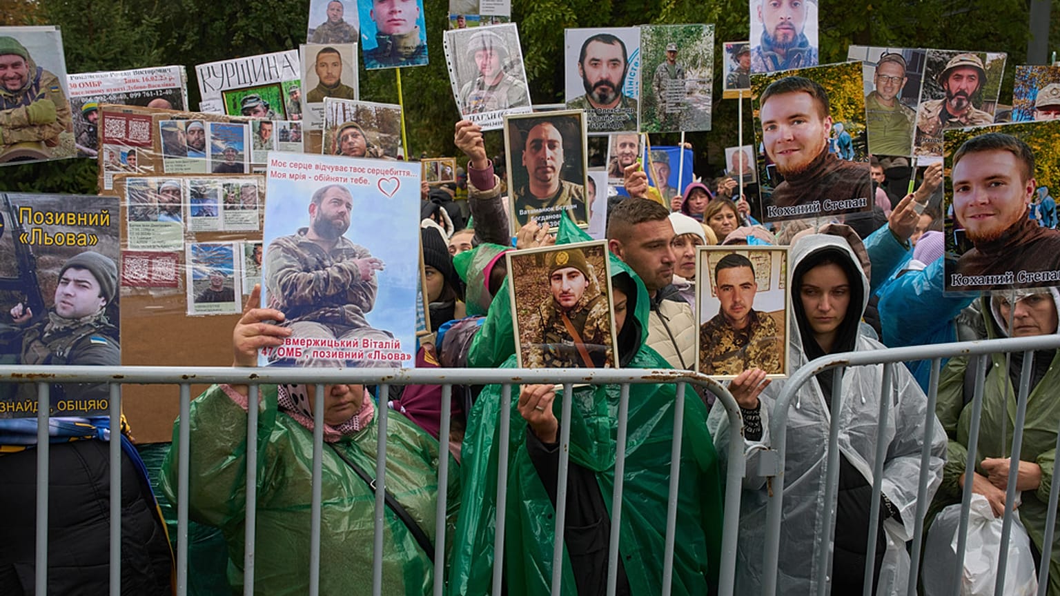 People hold photos of their missed relatives as Ukrainian soldiers return from captivity during a POW exchange between Russia and Ukraine in Chernyhiv region, Ukraine, Oct, 20