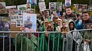 People hold photos of their missed relatives as Ukrainian soldiers return from captivity during a POW exchange between Russia and Ukraine in Chernyhiv region, Ukraine, Oct, 20