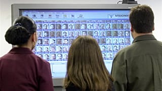 موظفو شركة Visionics Corp. في جيرسي سيتي، نيوجيرسي، ينظرون إلى شاشة كبيرة تعرض وجوههم في مكتب الشركة يوم الأربعاء 3 أكتوبر 2001.