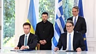 Volodimir Zelenszkij a görög miniszterelnökkel (a kép hátterében) 