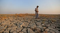 يسير صياد عبر رقعة جافة من الأرض في المستنقعات بمحافظة ذي قار، العراق، بتاريخ 2 سبتمبر 2022.