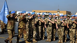 قائد اليونيفيل وقيادات ألمانية وإيطالية يستعرضون حرس الشرف في مرفأ بيروت خلال مراسم انتقال قيادة القوة البحرية من ألمانيا إلى إيطاليا في 30 تشرين الثاني/نوفمبر 2009.