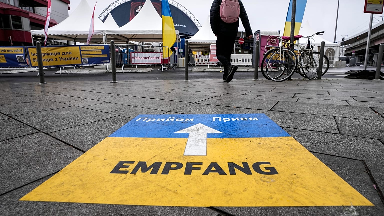 Ein Schild auf dem Bürgersteig weist Flüchtlingen den Weg zu einem Aufnahmezentrum am Hauptbahnhof in Köln, 4. April 2022.