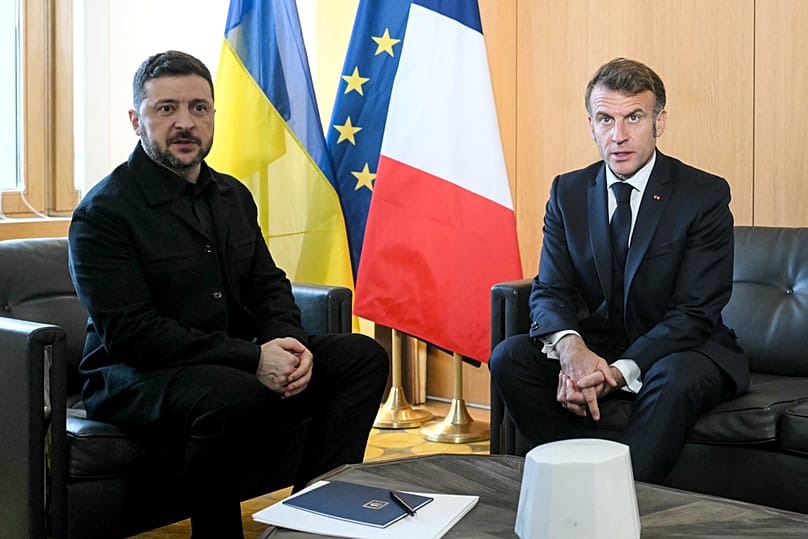 الرئيس الفرنسي إيمانويل ماكرون، والرئيس الأوكراني فولوديمير زيلينسكي يلتقطان الصور للصحفيين أثناء لقائهما على هامش قمة الاتحاد الأوروبي في بروكسل 