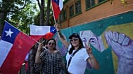 Supporters hold Chilean flags outside the polling station before Jeannette Jara's arrival during general elections in Santiago, 16 November 2025