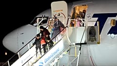 ينزل أشخاص تم إجلاؤهم من غزة من طائرة وصلت من مصر في قاعدة بازا 90 للقوات الجوية في أوتوپيني، رومانيا، يوم الأربعاء، 8 نوفمبر 2023
