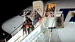 ينزل أشخاص تم إجلاؤهم من غزة من طائرة وصلت من مصر في قاعدة بازا 90 للقوات الجوية في أوتوپيني، رومانيا، يوم الأربعاء، 8 نوفمبر 2023