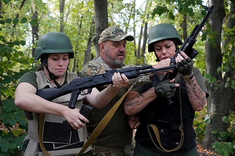  A Ukrainian serviceman instructs women to use rifles during a training course for national resistance for local population in Kharkiv region, Ukraine, Friday, Sept.13, 2024. 