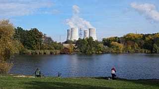 People fish near the towering Dukovany nuclear power plant, background, in Dukovany, Czech Republic.