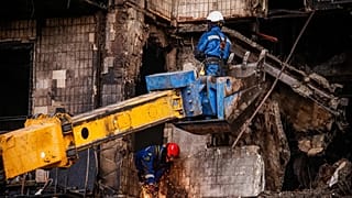 Strażacy pracują przy zniszczonym budynku mieszkalnym po rosyjskim ataku dronów w Kijowie na Ukrainie, w niedzielę 26 października 2025 r. (AP Photo/Dan Bashakov)