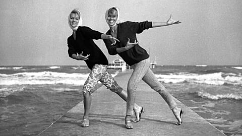Twin dancers Alice (with longer trousers) and Ellen Kessler rehearse a new dance step on the beach of the Hotel Excelsior on the Venice Lido, 20/08/1961
