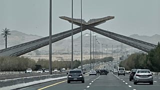 خودروها از زیر یک دروازه طاق‌مانند یادبود در بزرگراه جده ـ مکه، معروف به «دروازه قرآن»، عبور می‌کنند؛  ۲ ژوئن ۲۰۲۵