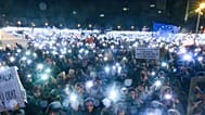 People hold mobile phones with flashlights during a rally to celebrate the 36th anniversary of the pro-democratic Velvet Revolution, in Bratislava, Slovakia, Nov. 17, 2025.