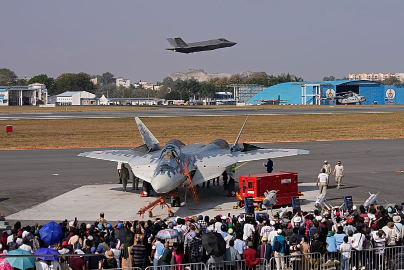 Истребитель ВВС США F-35 пролетает над российским истребителем Су-57, припаркованным на статической стоянке, на четвертый день выставки Aero India 2025