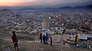 FILE: A boy flies a kite on a hilltop overlooking Kabul, 27 February 2022
