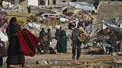 Filistinli bir adam, Gazze Şeridi'nin güneyindeki Han Yunus'ta çöplerden topladığı torbaları taşıyor, 15 Kasım 2025.