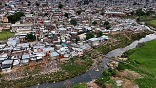 Volunteers help clean the polluted Jukskei River "prone" to flash floods