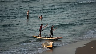 صيّادون في زورق مصنوع يدويًا يعودون إلى الشاطئ في مخيم الشاطئ بمدينة غزة، الثلاثاء، 18 نوفمبر 2025. 
