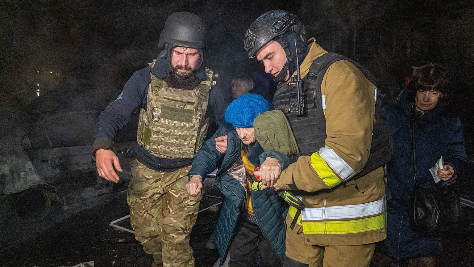 Rescuers evacuate an elderly woman after a residential building was hit following Russia's missile attack in Kharkiv, Ukraine Wednesday, Nov. 19, 2025.