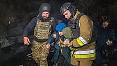 Kurtarma ekipleri, 19 Kasım 2025, Çarşamba günü Ukrayna'nın Kharkiv kentinde Rusya'nın füze saldırısının ardından bir konutun vurulmasının ardından yaşlı bir kadını tahliye ediyor.