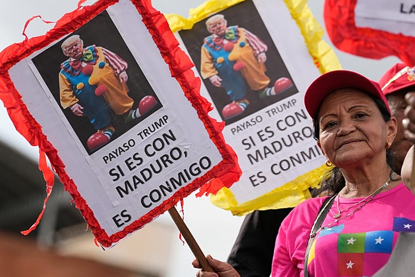 امرأة ترفع لافتة مكتوبًا عليها بالإسبانية "ترامب المهرج، إذا كنتَ ضد مادورو، فأنت ضدي" بكاراكاس، فنزويلا، السبت 15 نوفمبر 2025.