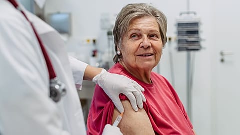 An older woman receives a vaccine.
