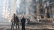People look at a residential building which was heavily damaged after a Russian strike on Ternopil