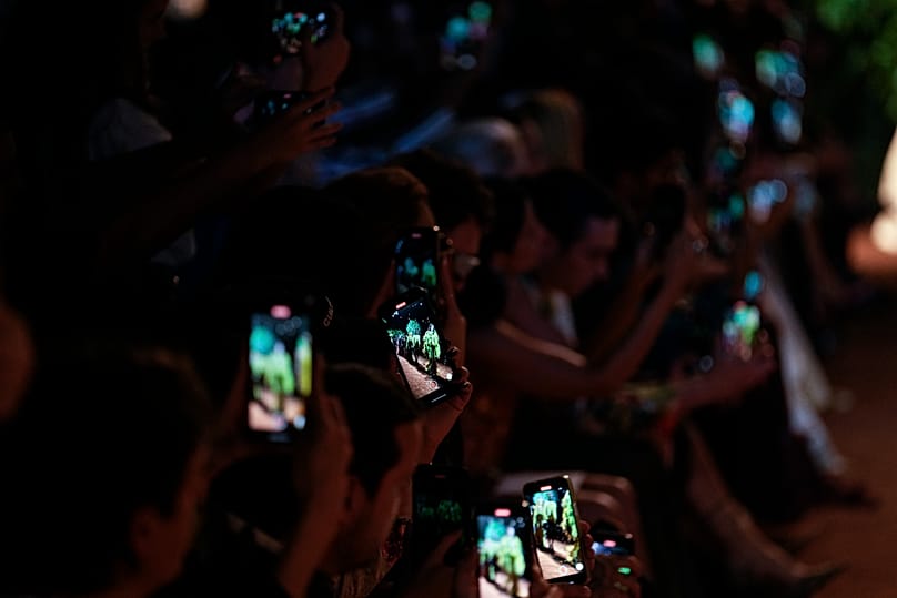 FILE: Guests use their mobile phones to record the Roberto Cavalli women's Spring Summer 2024 collection presented in Milan, Italy, 20 September 2023