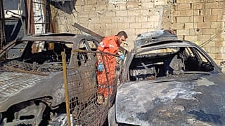 Bir ilk yardım görevlisi, Lübnan'da hava saldırıları sonrası hasar gören bir aracı incelerken, 19 Kasım 2025