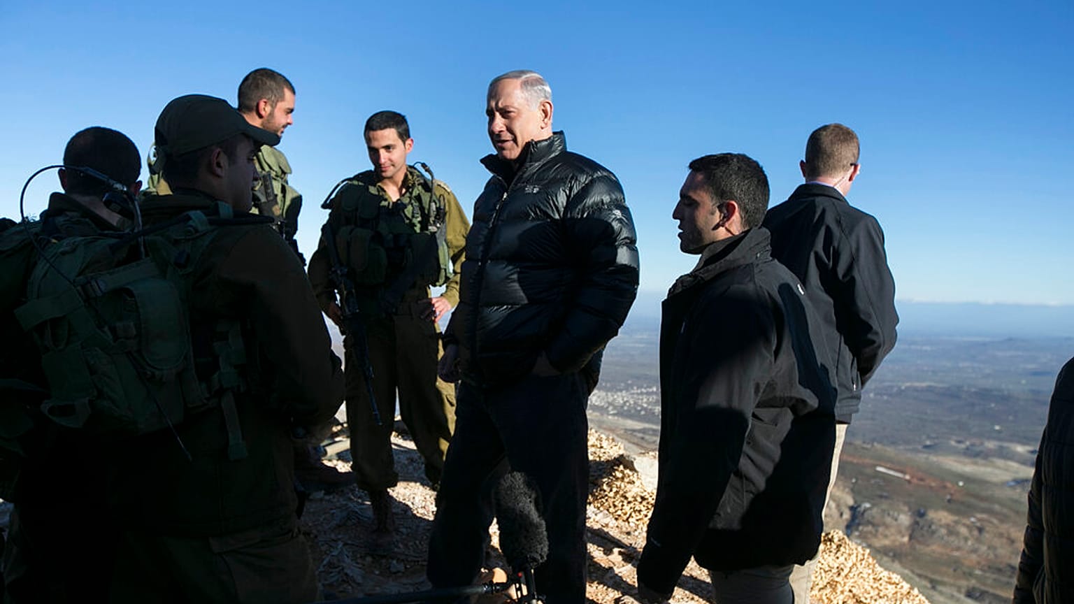 صورة أرشيفية رئيس الوزراء الإسرائيلي بنيامين نتنياهو (وسط الصورة) يتحدث مع جنود إسرائيليين في موقع عسكري خلال زيارة لجبل الشيخ في مرتفعات الجولان التي تسيطر عليها إسرائيل والم