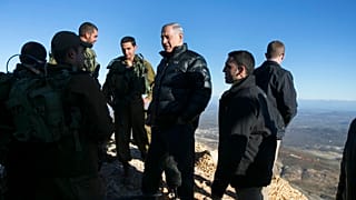 صورة أرشيفية رئيس الوزراء الإسرائيلي بنيامين نتنياهو (وسط الصورة) يتحدث مع جنود إسرائيليين في موقع عسكري خلال زيارة لجبل الشيخ في مرتفعات الجولان التي تسيطر عليها إسرائيل والم