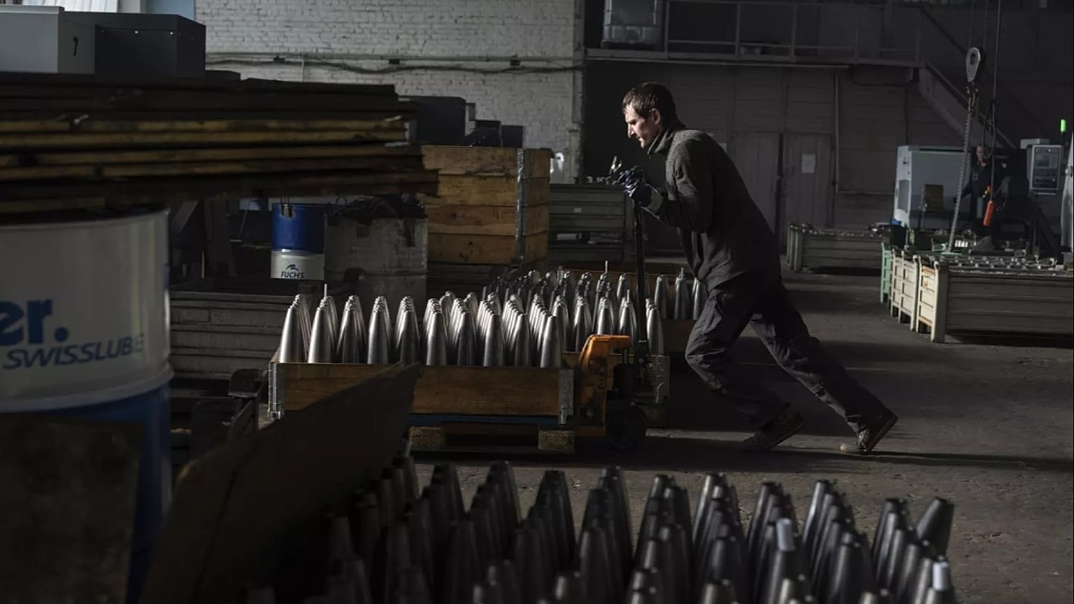 A worker carries a cart with mortar shells in a warehouse in Ukraine, Wednesday 31 January 2024