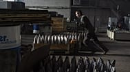 A worker carries a cart with mortar shells in a warehouse in Ukraine, Wednesday 31 January 2024