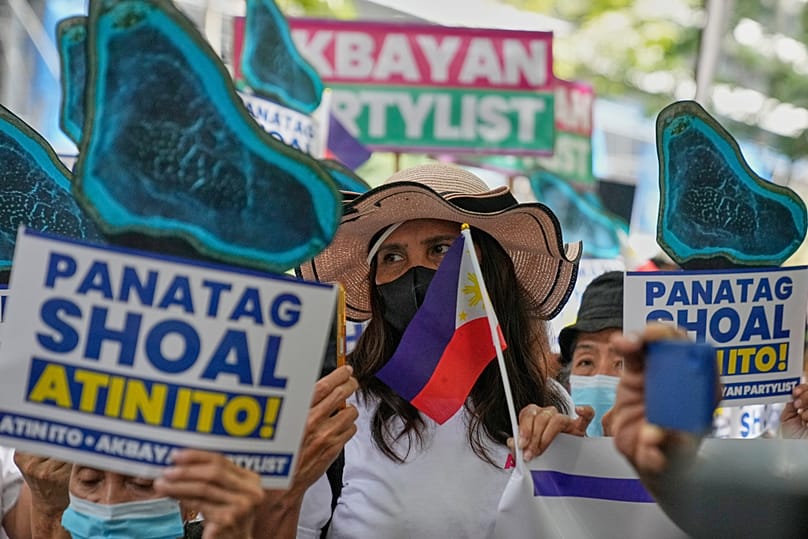 Protesters hold pictures of Scarborough Shoal, locally called Panatag Shoal, during a rally outside the Chinese Consulate in Makati, 22 October, 2025 