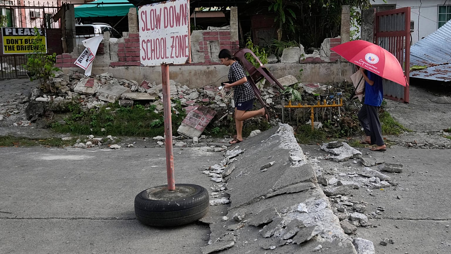 يسير السكان على طريق متضرر بسبب زلزال قوي وقع مؤخرا في مدينة بوجو, مقاطعة سيبو, وسط الفلبين يوم الخميس, أكتوبر. 2, 2025.